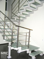 Baluster from polished stainless steel of two stepped string staircase with glass stair