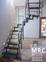 Staircase with coloured stages from glass triplex and with baluster from polished stainless steel