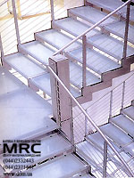 Double-turned staircase with baluster from stainless steel and with stages from tempered glass