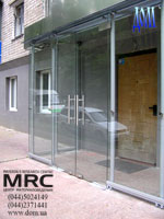 Glass entrance lobby. Handling of glass door from polished stainless steel